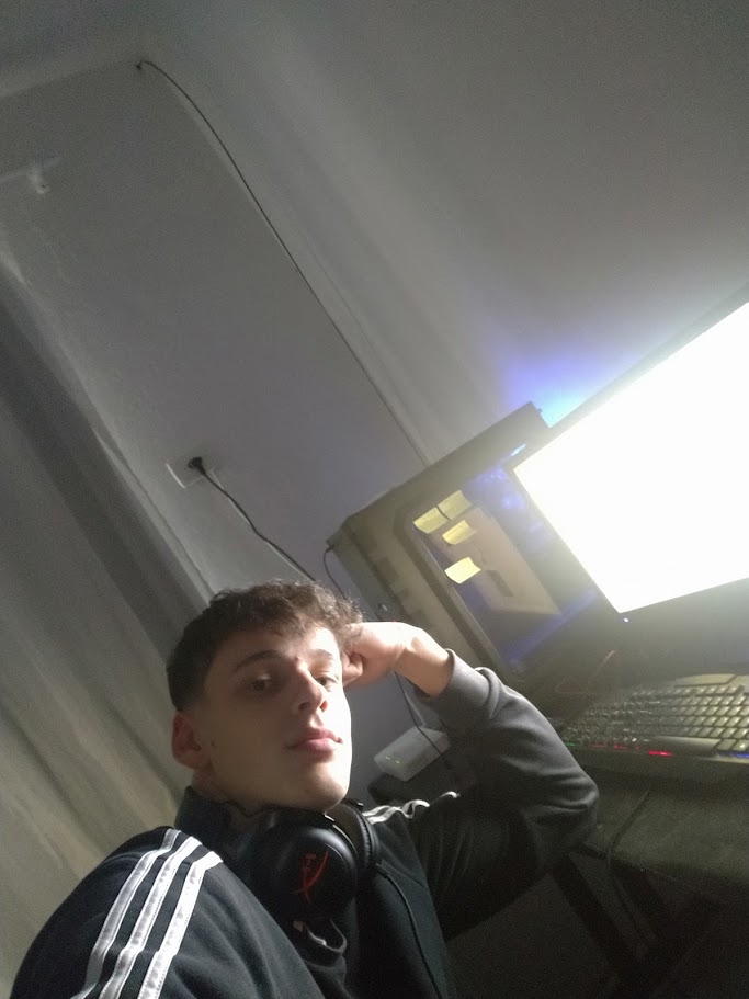 Iago de fone no pescoço, recostado diante do computador onde editava