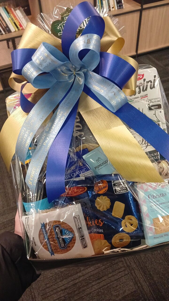 Cesta de presentes com laço azul e dourado, recebida na efetivação