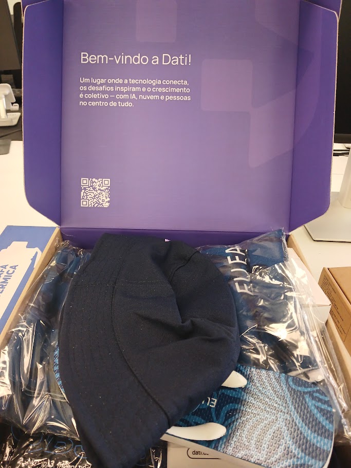 Kit de boas-vindas da Dati aberto, com a mensagem "Bem-vindo à Dati!" na tampa